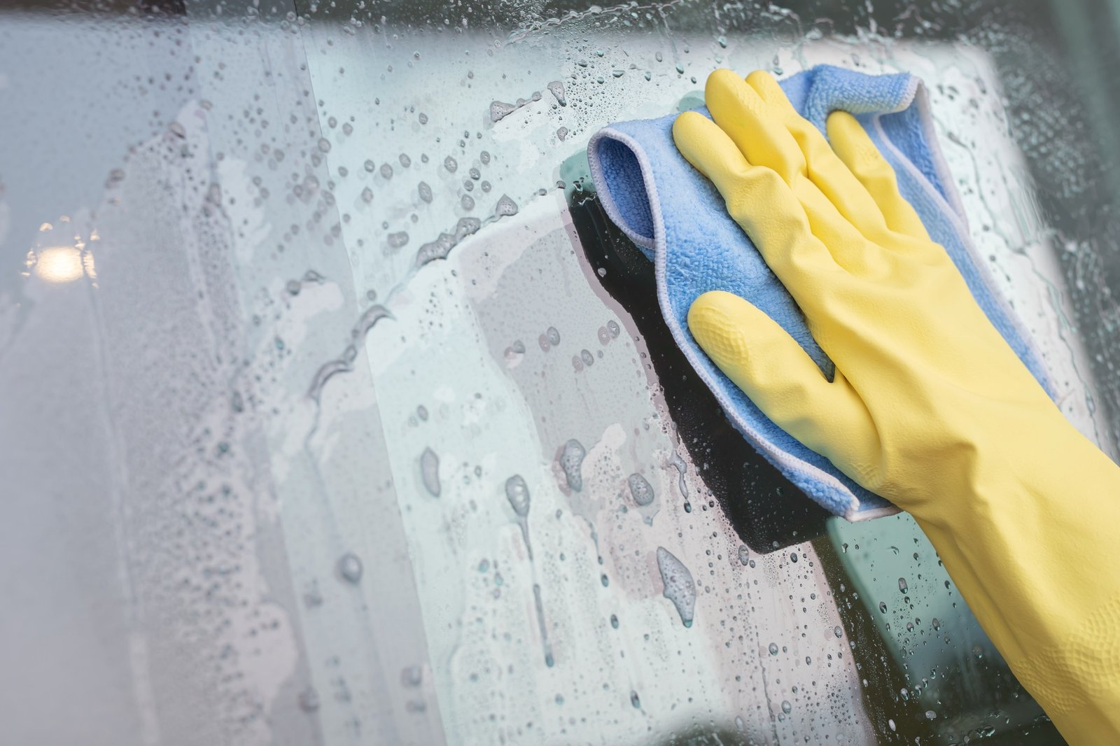 Woman cleaning window at home